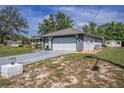 Single-story home with an attached garage, long driveway, and a storage shed at 3009 Ainsworth Ave, Spring Hill, FL 34609
