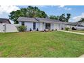 Charming single-story home with a well-manicured lawn, driveway, and white fence at 3733 Mendocino St, New Port Richey, FL 34655