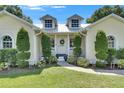 Inviting entrance of a home with a well-maintained lawn and decorative shrubbery along the walkway at 4312 James L Redman Pkwy, Plant City, FL 33567
