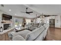 Open-concept living room with a brick fireplace, comfortable seating, and hardwood floors throughout at 4312 James L Redman Pkwy, Plant City, FL 33567