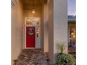 Close-up of the red front door, showing brick walkway, wreath, exterior pillar and hanging light at 5604 Pine Bay Dr, Tampa, FL 33625