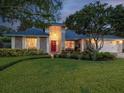 Beautiful single-story home with mature trees, brick accents, and a cozy front porch at dusk at 5604 Pine Bay Dr, Tampa, FL 33625