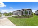 Well-maintained home showcasing a lush green lawn, paver driveway, and pristine exterior at 6072 Silver Grass Ct, Nokomis, FL 34275