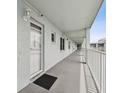 Outdoor walkway with light blue walls, white railing and a black doormat at 701 Poinsettia Rd # 322, Belleair, FL 33756
