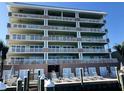Multi-story waterfront condo featuring spacious balconies and dockside seating on a sunny day at 706 Bayway Blvd # 502, Clearwater Beach, FL 33767