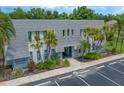 Exterior daytime shot of condo building, showing palm trees, a gray roof, and convenient parking at 720 Lyndhurst St # 1101, Dunedin, FL 34698