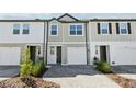 Modern townhomes feature mixed exteriors with driveways and attractive landscaping at 7678 Deer Valley Circle, Tampa, FL 33635