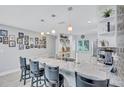 Open kitchen features a marble counter with bar seating, stainless steel appliances, and modern pendant lights at 900 Maclaren N Dr # D, Palm Harbor, FL 34684