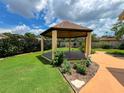 Wooden gazebo with lush landscaping and adjacent walkway leading to backyard at 9951 121St St, Seminole, FL 33772