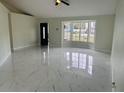 Spacious living area featuring polished marble flooring, a bay window, and natural light at 10444 Fordham St, Spring Hill, FL 34608