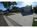 Wide street view of a single-Gathering home and lush green lawn on a sunny day at 10921 Brightside Dr, Tampa, FL 33624