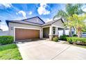 Inviting single-Gathering home features a well-maintained lawn, landscaping and a two-car garage at 11011 Little Blue Heron Dr, Riverview, FL 33579
