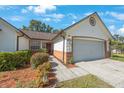 Attractive single-story home boasts a two-car garage, tidy landscaping, and a welcoming brick-accented entrance at 12405 Pathway Ct, Riverview, FL 33569