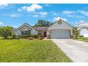 Charming single-story home showcases a manicured lawn, two-car garage, and classic brick-accented architecture at 12405 Pathway Ct, Riverview, FL 33569