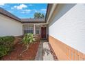 Inviting front entrance shows a red front door, neat landscaping, and brick accents under a bright sky at 12405 Pathway Ct, Riverview, FL 33569