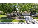 Inviting home exterior featuring a two-car garage, mature trees, and a neatly maintained front yard at 15820 Sapwood St, Tampa, FL 33624