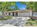 Inviting exterior with an attached two-car garage, a seating bench and a well-manicured front yard and a driveway at 15820 Sapwood St, Tampa, FL 33624
