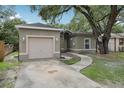 Single-story home with stucco exterior, attached garage, and mature landscaping at 1605 Prescott S St, St Petersburg, FL 33712