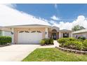Inviting single-story home with a well-manicured lawn, attached garage, and lovely landscaping at 1716 Bermuda Ct, Safety Harbor, FL 34695
