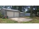 Spacious two-car garage with metal doors and a concrete pad, plus smaller sheds at 1908 S Kingsway Rd, Seffner, FL 33584
