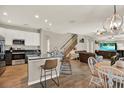 Open kitchen featuring stainless steel appliances, granite countertops, an island with seating, and hardwood floors at 20835 Lake Talia Blvd, Land O Lakes, FL 34638