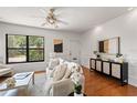 Well-lit living room with hardwood floors, neutral decor, and a large window at 217 W Powhatan Ave, Tampa, FL 33604