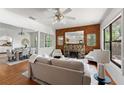 Bright living room featuring hardwood floors, a stone fireplace and a ceiling fan at 217 W Powhatan Ave, Tampa, FL 33604
