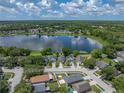 Stunning aerial view of home on a lake with lush surrounding greenery and a blue sky with fluffy clouds at 22829 Saint Thomas Cir, Lutz, FL 33549
