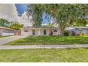 Cozy home showcasing a neat front yard with mature trees and a well-maintained lawn at 2848 Homewood St, Clearwater, FL 33759