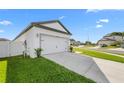 Exterior view of home, highlighting the attached two-car garage and landscaped front yard at 29245 Fedora Cir, Brooksville, FL 34602