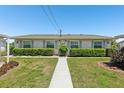 Charming home featuring a well-manicured lawn and trimmed hedges for added curb appeal at 301 Canton Ct # 77, Sun City Center, FL 33573
