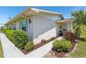 Landscaped pathway leads to the front of this home with fresh mulch and tropical plants at 301 Canton Ct # 77, Sun City Center, FL 33573