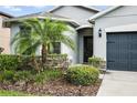 Close up of the front of the house, showing the door, landscaping, and two car garage at 3025 Winglewood Cir, Lutz, FL 33558