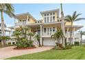Charming two-story home with multi balconies, a two car garage, and beautiful palm trees at 442 Midway Is, Clearwater Beach, FL 33767