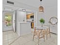 Bright condo dining nook with backyard views, white table with two chairs and a kitchenette with wood cabinets at 4540 Overlook Ne Dr # 246, St Petersburg, FL 33703
