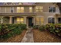 Charming townhouse featuring a stucco facade, lush landscaping, and inviting entryway at dusk at 4668 66Th N Pl, Pinellas Park, FL 33781