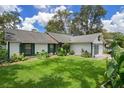 Attractive single Gathering home with green shutters, lush landscaping, and a well maintained lawn at 5301 Bayonne Ave, Spring Hill, FL 34608