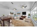 Bright living room features neutral furniture, ceiling fans, tile flooring and large windows for ample natural light at 547 Summer Sails Dr, Valrico, FL 33594