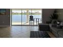 Living room with peaceful views of the lake, couch, and black ottoman at 5494 Sabal Trace Dr, North Port, FL 34287