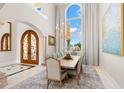 Elegant dining room with chandelier, arched doorway, and large windows providing abundant natural light at 611 1St S Ave, Tierra Verde, FL 33715