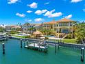 Waterfront home featuring a boat dock, outdoor kitchen, pool, and covered patio with water views at 611 1St S Ave, Tierra Verde, FL 33715