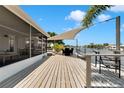 Spacious wooden deck overlooking the water, complete with seating, shade, and a screened-in porch at 805 Leisey Cir, Ruskin, FL 33570