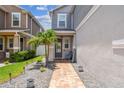 View of the entrance and front yard with brick pavers, lush landscaping, and gray stone at 8148 Artisan Cir, Seminole, FL 33777