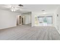 Open living room with neutral carpet, ceiling fan, and views to a dining area and beyond at 8319 Annwood Rd, Seminole, FL 33777