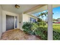 Inviting front porch with tiled flooring, a modern front door, and manicured landscaping at 8671 11Th N St, St Petersburg, FL 33702