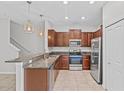 Stylish kitchen featuring stainless steel appliances, granite counters, and modern lighting fixtures at 9768 Pembrooke Pines Dr, Sun City Center, FL 33573