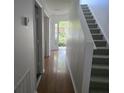 Hallway features hardwood floors, stairs, and a clear view of the front door leading to the outside at 9958 Ashburn Lake Dr, Tampa, FL 33610