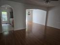 Inviting living room with hardwood floors, arched doorways, and a view into the kitchen at 9958 Ashburn Lake Dr, Tampa, FL 33610