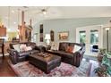 Cozy living room featuring hardwood floors, a ceiling fan, and comfortable leather furniture at 10597 Alvarado Ct, Seminole, FL 33772