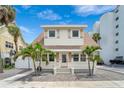 Charming two-story home with a unique roofline, a light pink door, and lovely palm trees at 108 5Th Ave, St Pete Beach, FL 33706